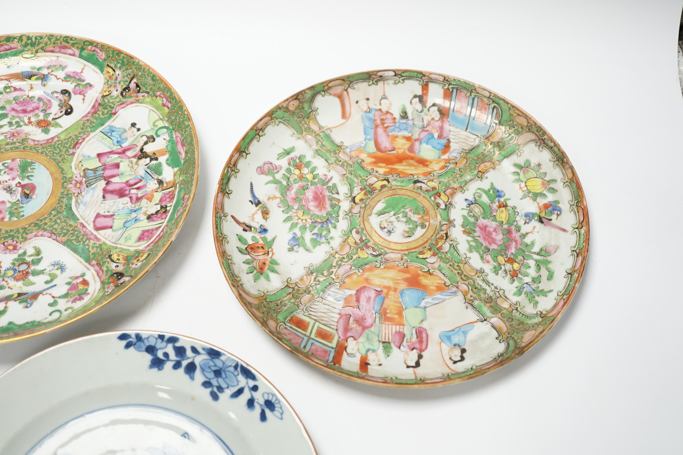 Two 19th century Chinese famille rose plates and an 18th century blue and white plate, 24cm in diameter
